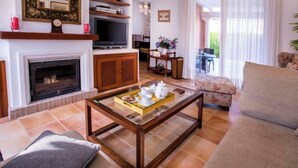 Ein Wohnzimmer mit Kamin, Fernseher und einem Couchtisch mit Teekannen.