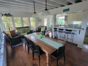 A spacious dining area with a wooden table, black chairs, and a green placemat.