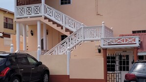 Ein Gebäude mit einer beige farbenen Fassade, einer weißen Treppe und einem verschlossenen Eingang.