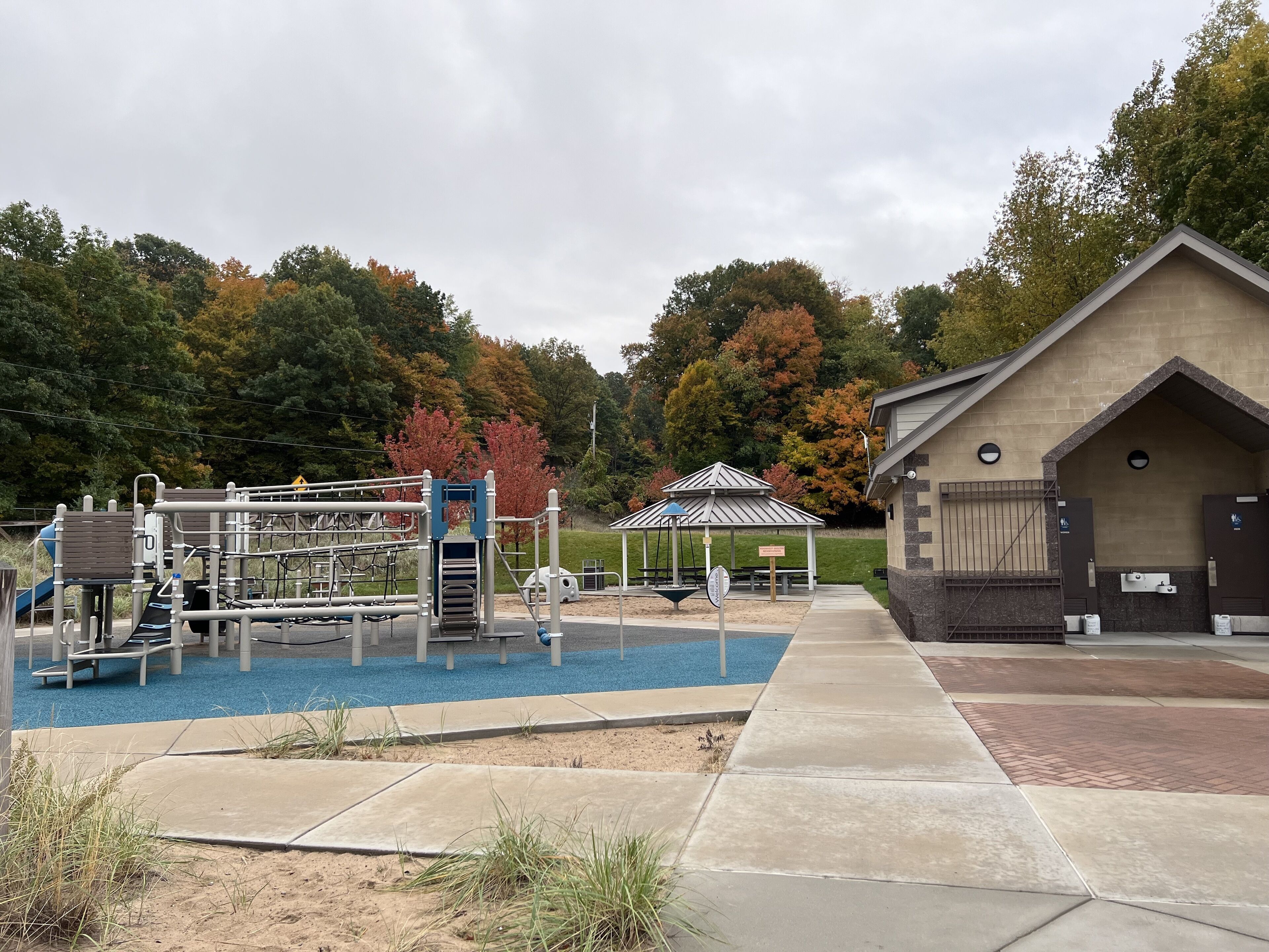 A playground with climbing structures and a picnic shelter.