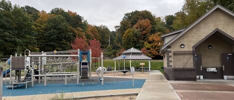 A playground with climbing structures and a picnic shelter.