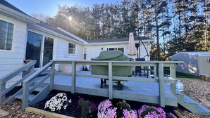 A residential area with a covered patio, a wooden deck, and a garden with flowers. - Hot tub, Nature, Parks and Beaches! Right in between Holland and Grand Haven. (West Olive)