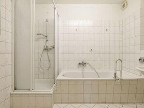 Un baño con cabina de ducha, bañera y lavamanos.