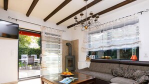 A living room with a sofa, a glass coffee table, a fireplace, and a TV mounted on the wall. - Vacation home Petra by Interhome (Neeberg)