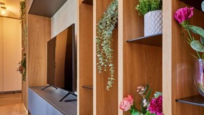 A modern hotel room with a wooden reception desk, a flat-screen TV, and decorative plants. - Summit View Lounge & Alcove by Interhome (Pec pod Snezkou)