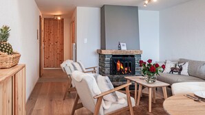 A cozy living room with a fireplace, wooden furniture, and a dining area. - Haut de Cry 16 by Interhome (Nendaz)