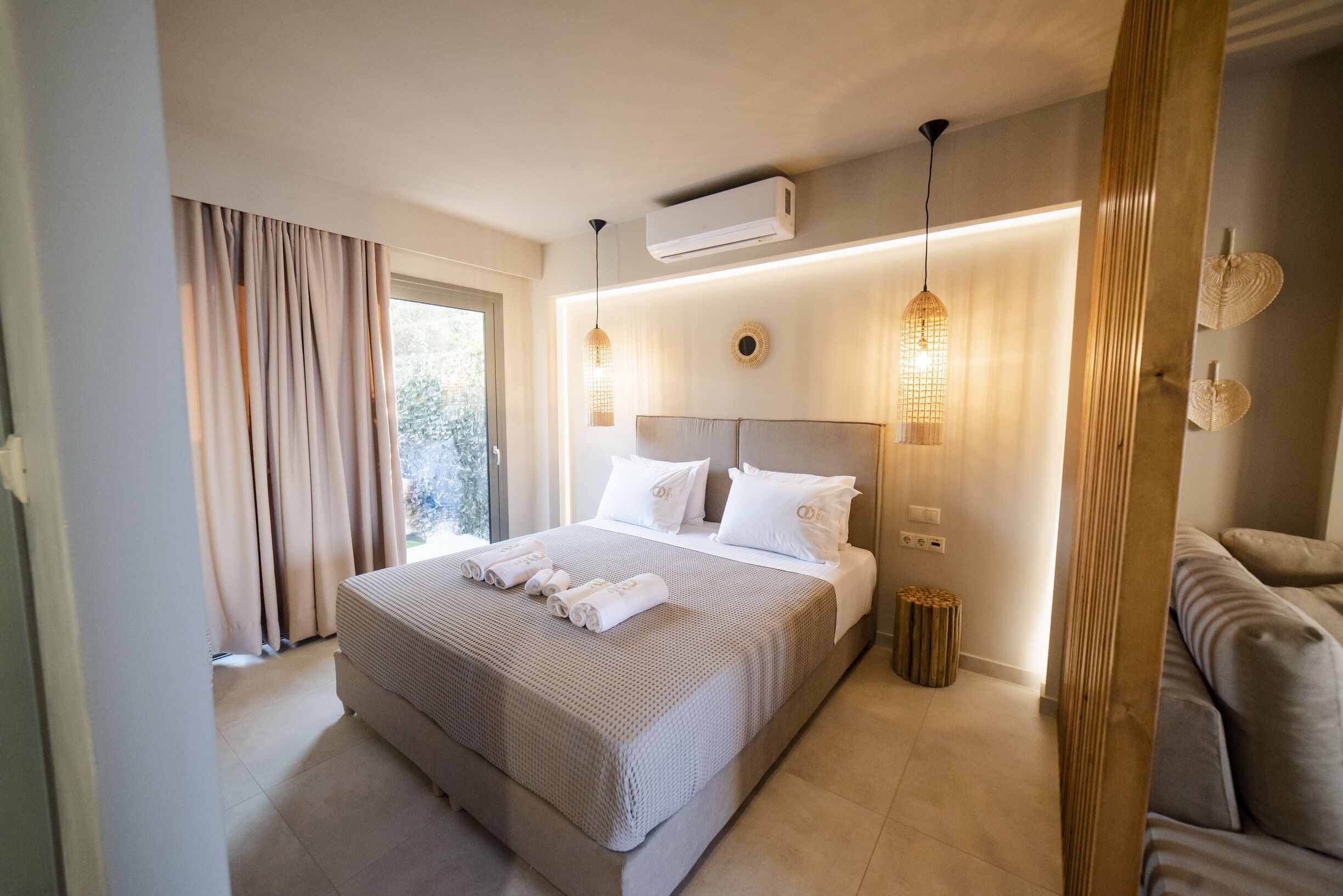 Une chambre d’hôtel moderne avec un grand lit, un canapé et une petite table d’appoint.