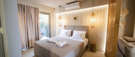 Une chambre d’hôtel moderne avec un grand lit, un canapé et une petite table d’appoint.