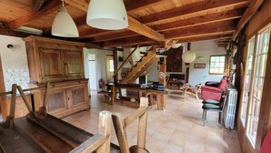 Interior rústico em madeira, com cozinha, escada de madeira e áreas de estar.