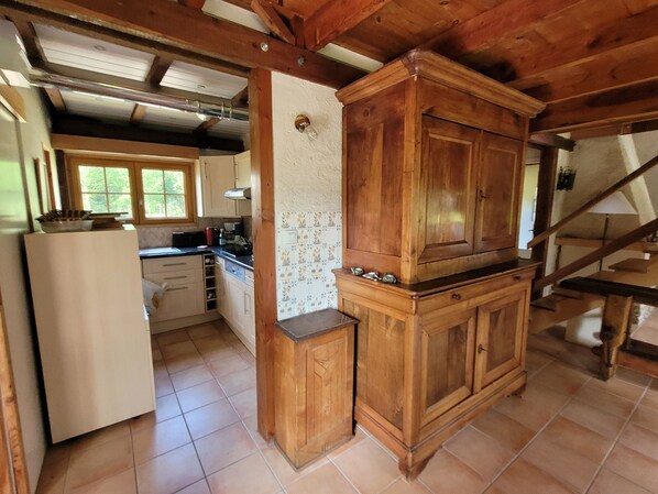 A kitchen with wooden cabinets, a refrigerator, and a tiled backsplash. - Chalet 8 Personnes - Dévoluy (Le Dévoluy)