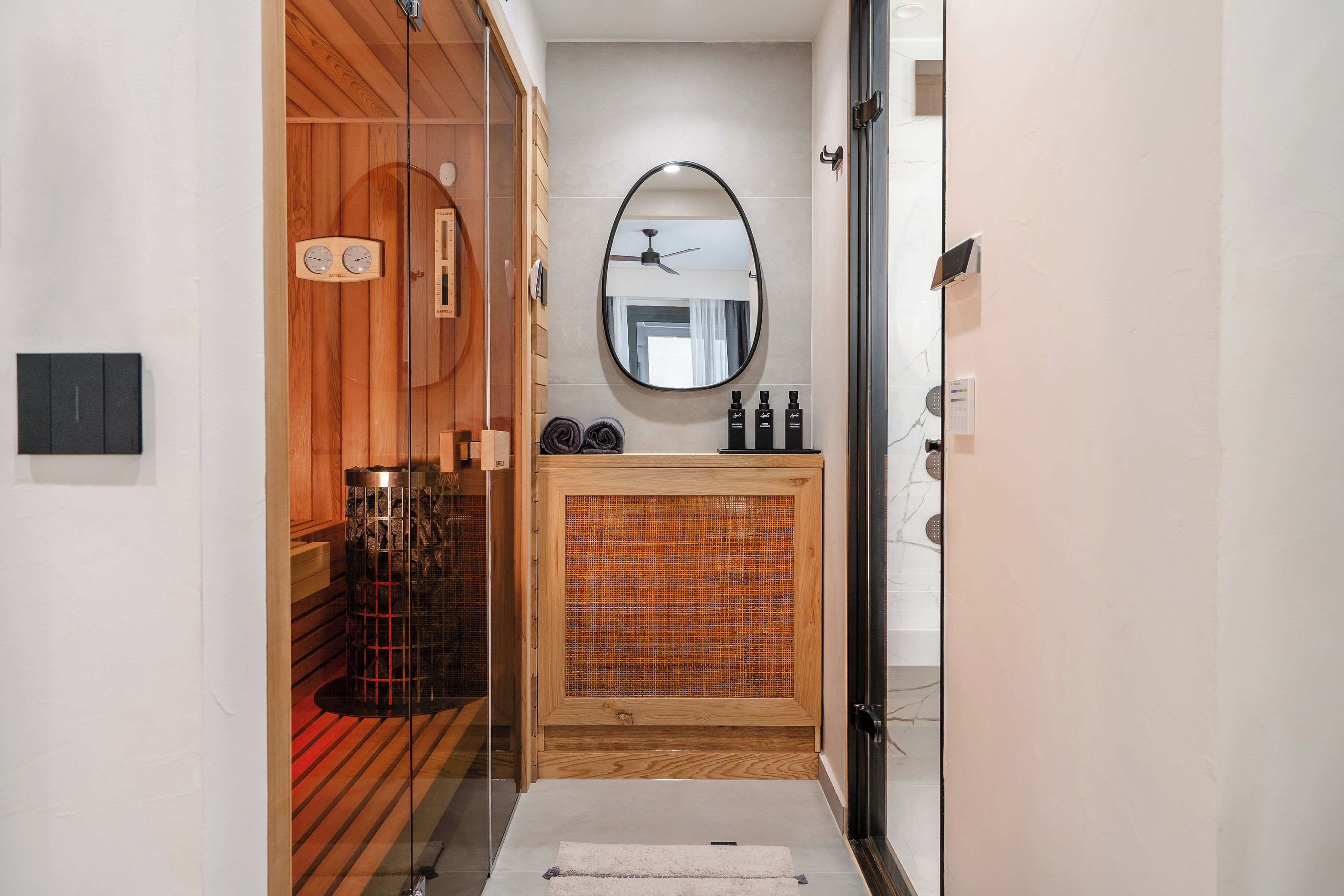 Een moderne badkamer met een houten wastafelmeubel, een spiegel en een plafondventilator.