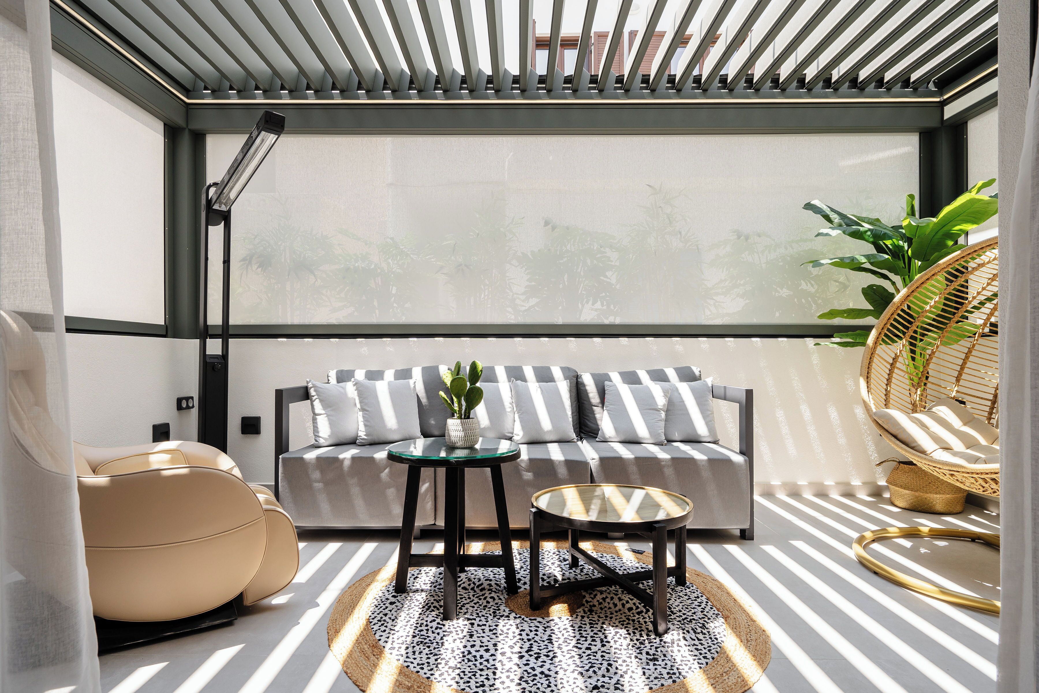 A modern balcony with a sofa, a round table, and a chair.