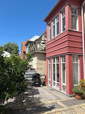 A red building with large windows and a wooden deck. - Underbart Town House på Ön, Limhamn med Alla Bekvämligheter (Skåne län)