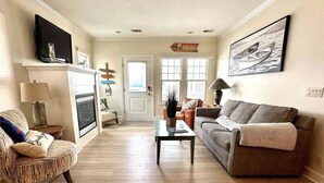 A living room with a fireplace, a sofa, a coffee table, and a television.