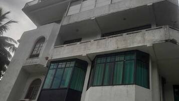 A multi-story building with balconies and large windows.