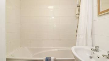 A bathroom with a bathtub, a sink, and a shower.