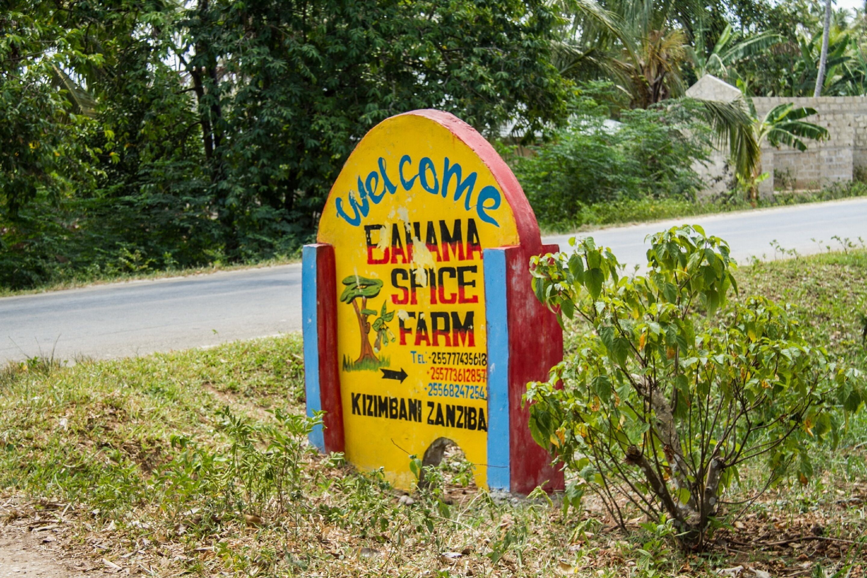 A colorful welcome sign for a farm with contact information.