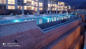 A hotel with a swimming pool, lounge chairs, and a mountainous backdrop. - Sea view il monte galala chalet 3bedroom (Suze)
