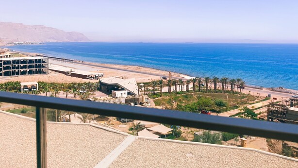 A coastal view with a beach, palm trees, and a building under construction. - Sea view il monte galala chalet 3bedroom (Suze)