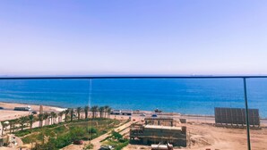 A coastal view with a clear sky, a sandy beach, and a road leading to a building with solar panels. - Sea view il monte galala chalet 3bedroom (Suze)