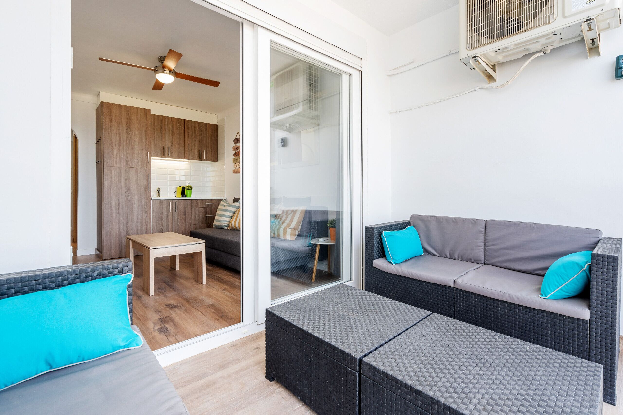 Un espace de vie moderne comprenant un canapé, une petite table et un banc en osier.