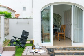 An outdoor patio with a table, chairs, a bottle, and glasses. - WELCS CASA 089 EMP cerca del mar (Empuriabrava)