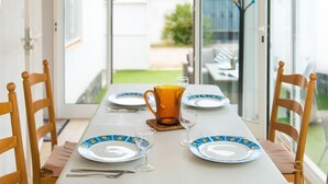 A dining table set with plates, glasses, and a pitcher, with chairs around it. - WELCS CASA 089 EMP cerca del mar (Empuriabrava)