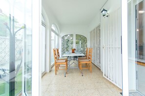 A dining area with a table and chairs, a decorative partition, and a view of the outdoors.