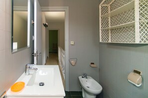 A bathroom with a white sink, a bidet, and a mirror. There is a door leading to another room. - WELCS CASA 089 EMP cerca del mar (Empuriabrava)