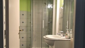 A bathroom with a shower, toilet, and sink.