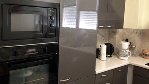 A kitchen with a Bosch microwave, oven, and coffee maker.