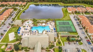Vista aèria d'una zona residencial amb piscina, pistes de tennis i un edifici gran amb teulada piramidal.