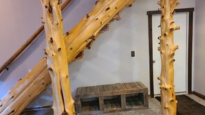 A room with a wooden bench, a door, and a wall-mounted light fixture.