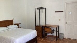 A bedroom with a bed, a desk, a chair, a wardrobe, and a door. - POSADA CAMPESTRE XICOTEPEC (Xicotepec)
