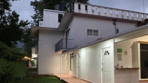 A modern building with a covered outdoor area, a small balcony, and a reception desk. - POSADA CAMPESTRE XICOTEPEC (Xicotepec)