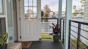 A wooden deck with a door leading to a view of a marina. - Oceans RV Resort (Holly Ridge)