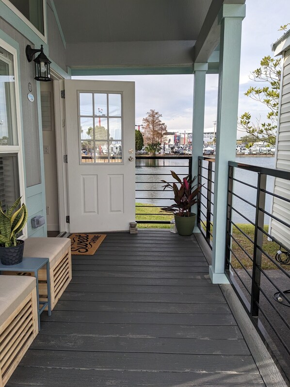 A wooden deck with a door leading to a view of a marina. - Oceans RV Resort (Holly Ridge)