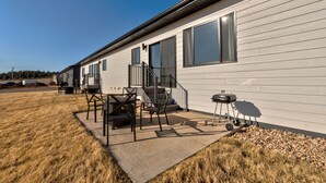A single-story mobile home with a patio area featuring outdoor furniture and a barbecue grill. - Luxury Rapid City Home #1 (Rapid City)