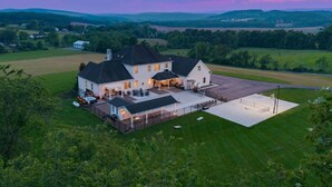 A large house with a spacious patio and a basketball court. - Willow Brook Mansion, an upscale retreat in the countryside with heated seasonal (May 1st - Oct. 1st) pool, hot tub and game room. (Millerstown)