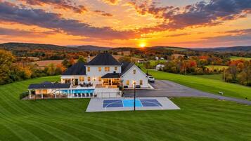 A large house with a swimming pool and a basketball court.