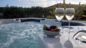 A hot tub with two glasses of white wine and a bowl of strawberries. - Villa Seaside - Dimora con jacuzzi a 200mt dal mare (Syracuse)