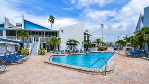 A swimming pool with lounge chairs and a staircase leading to a building.