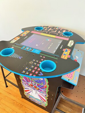 Une table au design coloré, dotée d’un écran et de poignées bleues.
