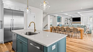 A modern kitchen with a central island, stainless steel appliances, and teal cabinetry. - Beautiful Bayfront w/ Heated Pool & Dock.  6 Bedrooms, all w/ Ensuite Bathrooms. (Ship Bottom)