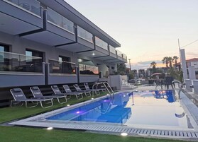 Una piscina al aire libre de temporada, sombrillas