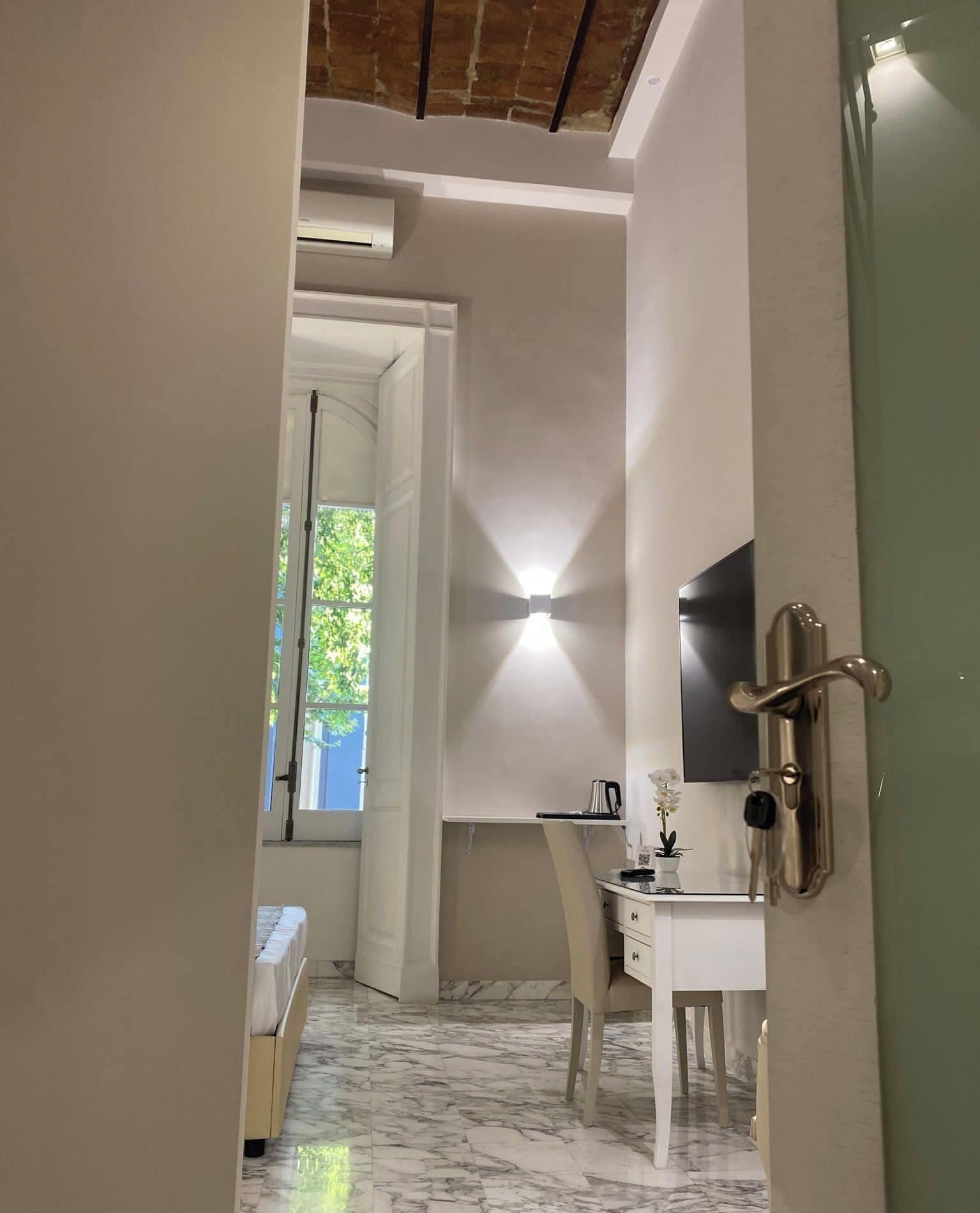 Une chambre moderne avec un lit, un bureau et un téléviseur.