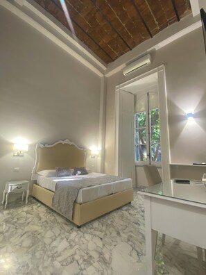 A bedroom with a bed, a bedside table, a mirror, and a desk. - MILUAR - Vanvitelli (Naples)