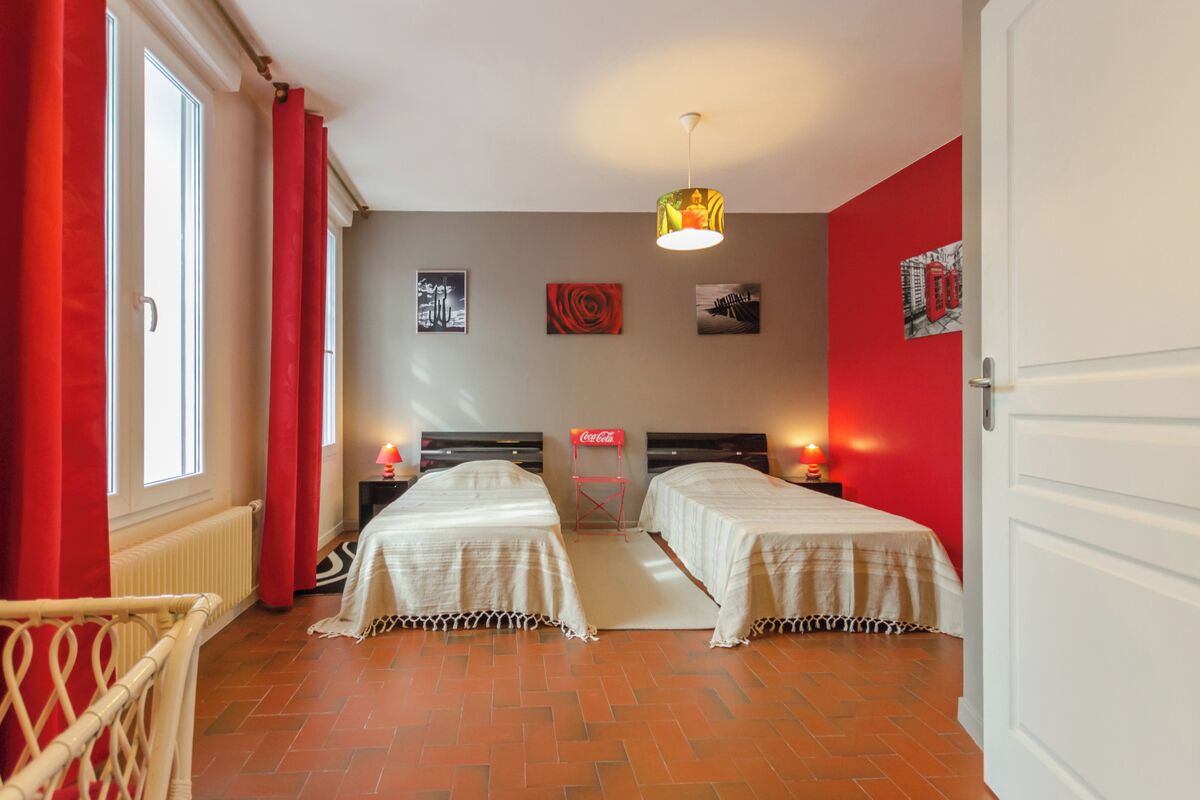Ein Zimmer mit zwei Betten, einer roten Wand und einem Coca-Cola-Schild.