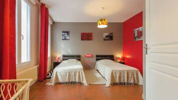 Ein Zimmer mit zwei Betten, einer roten Wand und einem Coca-Cola-Schild.