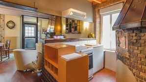 A modern kitchen with a built-in oven, a white refrigerator, and a brick accent wall.